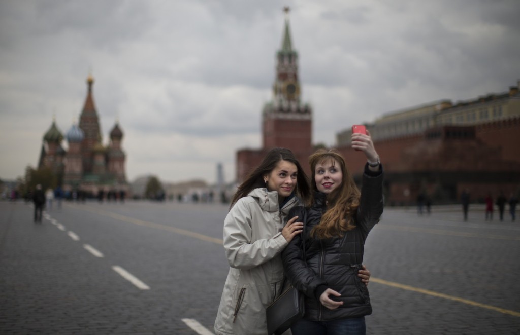 Duas jovens fazem selfie na Praça Vermelha, em Moscou | Foto: Alexander Zemlianichenko/AP