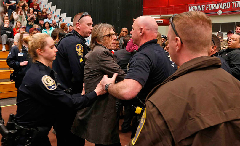 O fotógrafo foi retirado pela política sob aplausos dos estudantes | Foto: Steve Helber/AP